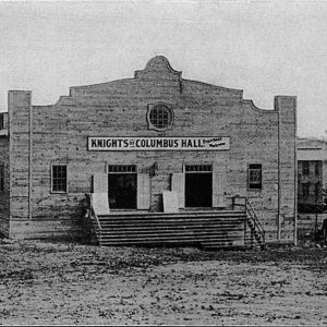 Building with stairs leading to double entrance with sign reading "Knights of Columbus Hall