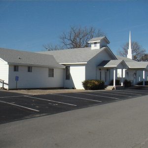 White single story church building with white steeple