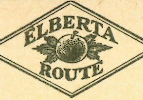 Diamond shaped outline drawing of peace and leaves in center with word "Elberta" above and "Route" below