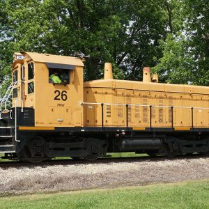 Train engine on railroad tacks with black tank car attached