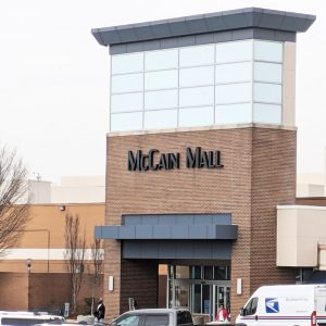 Multistory brick building in parking lot large sign "McCain Mall"