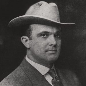 White man wearing suit and wide brimmed hat