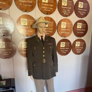 Mannequin dressed in military uniform in front of circular wooden displays each with names of individuals in the "founders circle"