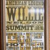 Wooden framed advertisement with text "American Legend Willie Nelson" list of other artists and time of performance framed between two stripes with five stars inside each