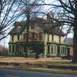 Three story Victorian styled house with ornate trimmings porch and second floor balconies