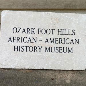 Concrete sign text "Ozark Foot Hills African American Museum"
