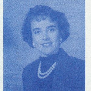White woman short curly hair wearing suit jacket turtleneck and pearl necklace with matching earrings smiling text "Elect Lambert for Congress"