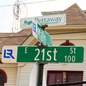 Two street signs under smaller sign with text "Pettaway Neighborhood"